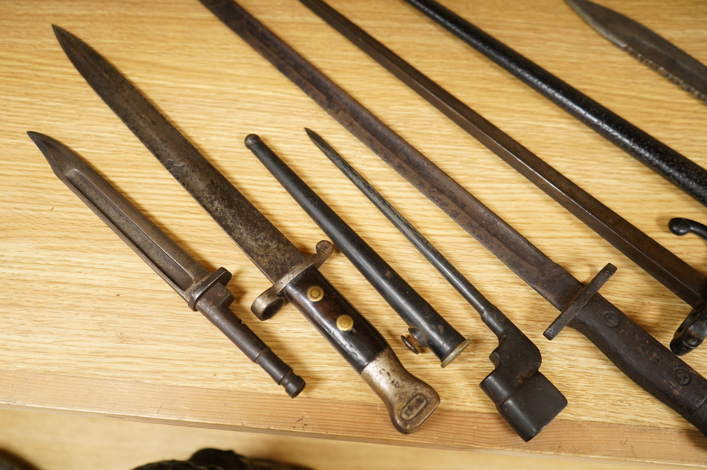 Seven bayonets; a speculative 20th century English bayonet of unknown type with broad arrow and other English type markings, together with a German butcher bayonet in scabbard (grips missing), a Gras bayonet and scabbard